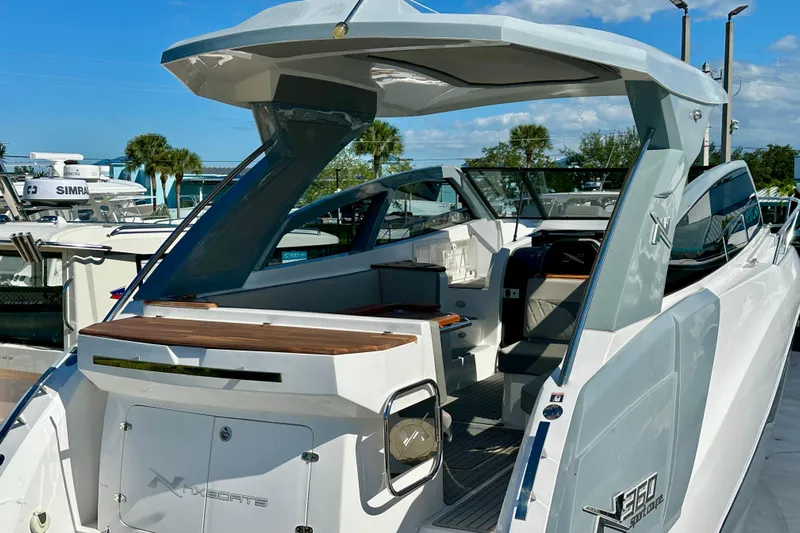  Yacht Photos Pics 2024 NX 360 Sport Coupe boat with sleek design and modern features docked under clear skies.