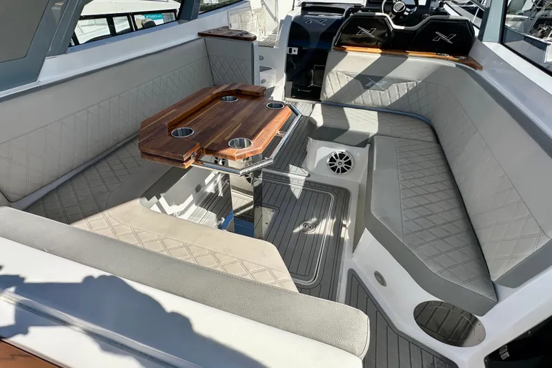  Yacht Photos Pics 2024 NX 360 Sport Coupe interior with luxurious seating and wooden table.