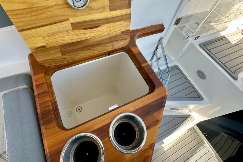  Yacht Photos Pics 2024 NX 360 Sport Coupe interior with wooden storage compartment and cup holders.