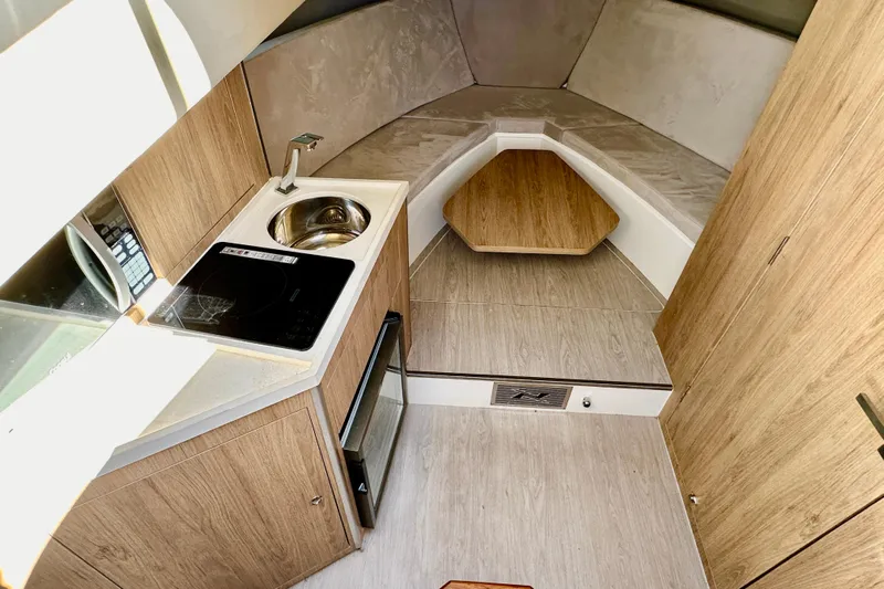  Yacht Photos Pics Interior of 2024 NX 360 Sport Coupe, featuring kitchenette and cozy sleeping area.
