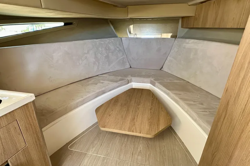  Yacht Photos Pics 2024 NX 360 Sport Coupe interior with beige seating and wooden table.