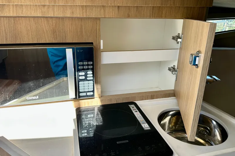  Yacht Photos Pics 2024 NX 360 Sport Coupe kitchen with microwave, induction cooktop, and sink.