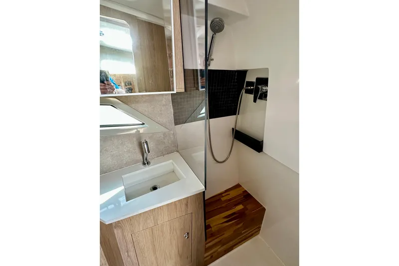  Yacht Photos Pics 2024 NX 360 Sport Coupe bathroom with modern sink, shower, and wooden accents.