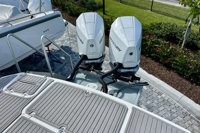  Yacht Photos Pics 2024 NX 360 Sport Coupe with dual Mercury Verado outboard engines, docked on paved surface.