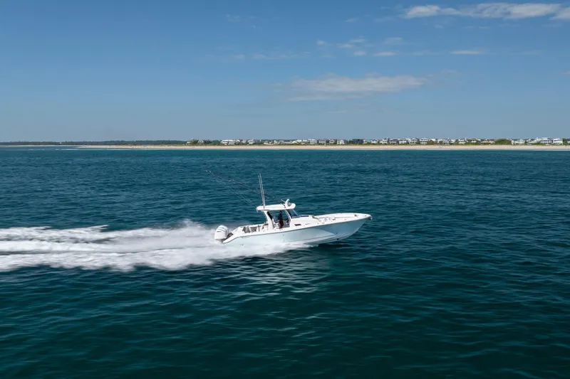  Yacht Photos Pics 2021 Edgewater 370CC boat cruising on open water under a clear blue sky.