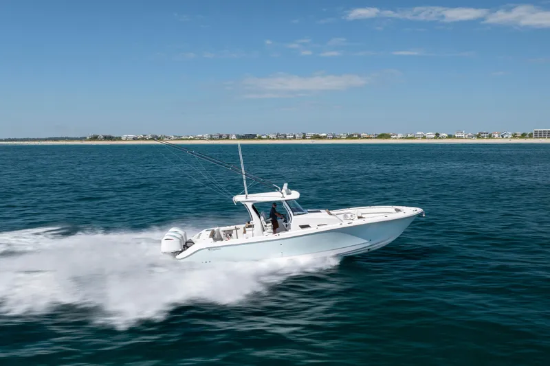  Yacht Photos Pics 2021 Edgewater 370CC boat cruising on open water near a distant shoreline.