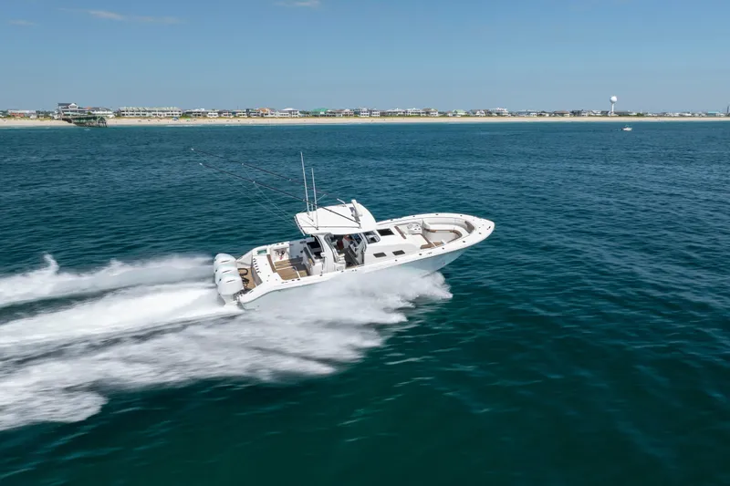  Yacht Photos Pics 2021 Edgewater 370CC boat speeding on ocean near coastline.