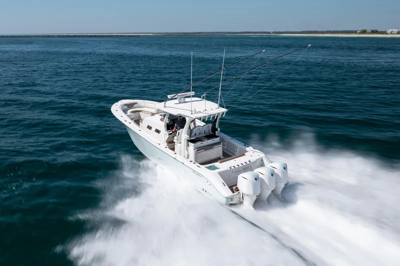  Yacht Photos Pics 2021 Edgewater 370CC boat speeding on open water with triple outboard engines.