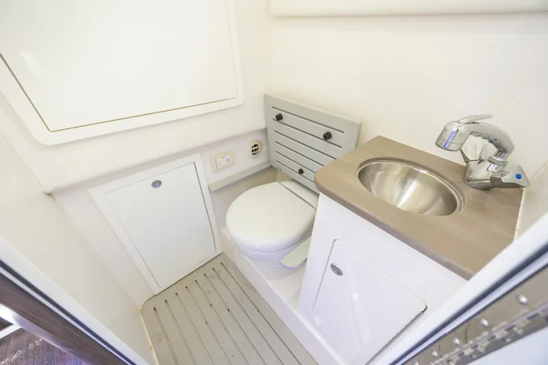  Yacht Photos Pics 2021 Edgewater 370CC boat bathroom with compact toilet and stainless steel sink.