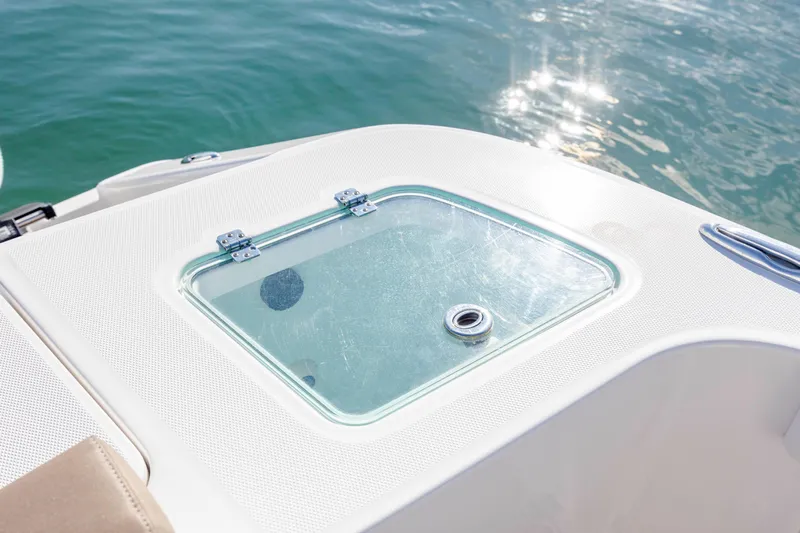  Yacht Photos Pics 2021 Edgewater 370CC boat deck with a glass hatch, reflecting sunlight on water.