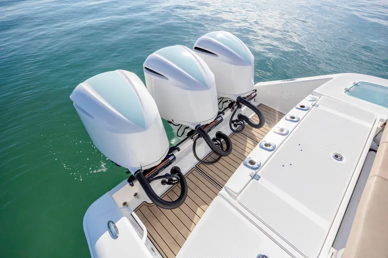  Yacht Photos Pics 2021 Edgewater 370CC boat with triple outboard engines on calm water.