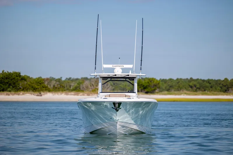  Yacht Photos Pics 2021 Edgewater 370CC boat on calm water with a scenic shoreline backdrop.