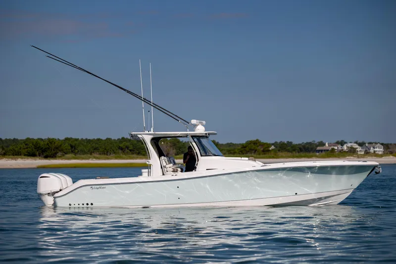 Yacht Photos Pics 2021 Edgewater 370CC boat on calm water with scenic shoreline background.
