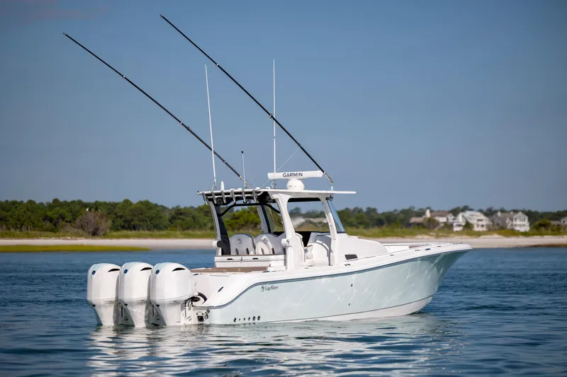  Yacht Photos Pics 2021 Edgewater 370CC boat with triple engines on calm water, near shoreline.