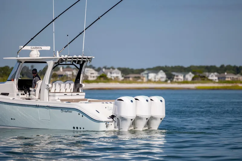  Yacht Photos Pics 2021 Edgewater 370CC boat with triple engines cruising near coastal homes.