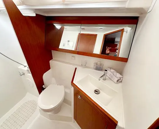 Journey Yacht Photos Pics 2019 Beneteau Oceanis 48 yacht bathroom with modern fixtures and wooden cabinetry.