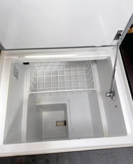 Journey Yacht Photos Pics Open storage compartment on 2019 Beneteau Oceanis 48 yacht, featuring a wire basket.