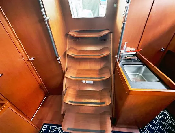 Journey Yacht Photos Pics Interior of 2019 Beneteau Oceanis 48 yacht with wooden stairs and compact sink area.