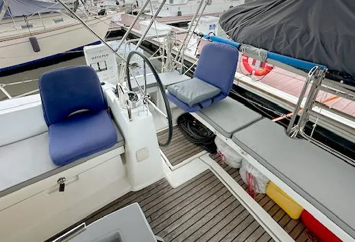 Journey Yacht Photos Pics Cockpit of 2019 Beneteau Oceanis 48 sailboat with blue cushions and steering wheel.