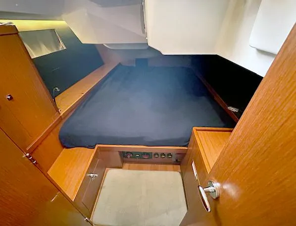 Journey Yacht Photos Pics 2019 Beneteau Oceanis 48 cabin interior with wooden finish and cozy bed.