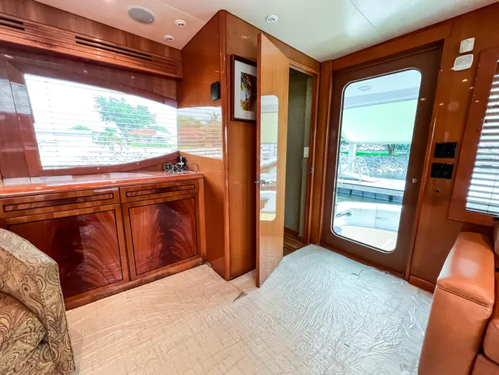  Yacht Photos Pics Luxurious interior of 2007 Hatteras 68 Convertible yacht with wooden cabinetry and outdoor view.