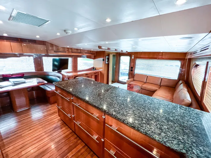  Yacht Photos Pics Luxurious interior of 2007 Hatteras 68 Convertible yacht with granite countertops and wooden flooring.