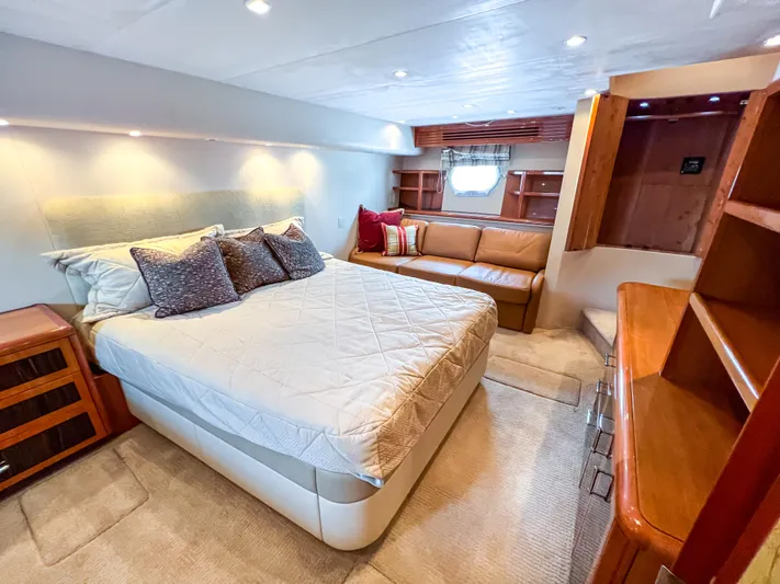  Yacht Photos Pics Luxurious bedroom interior of 2007 Hatteras 68 Convertible yacht with cozy bed and seating area.