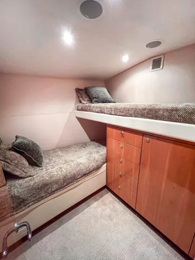  Yacht Photos Pics Cozy cabin interior of 2007 Hatteras 68 Convertible yacht with bunk beds and wooden cabinetry.