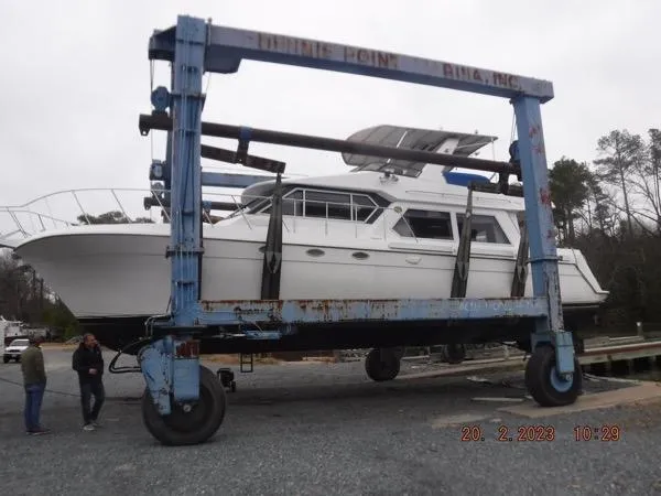  Yacht Photos Pics 1997 Navigator 5000 Classic yacht on a lift at a marina, surrounded by trees.