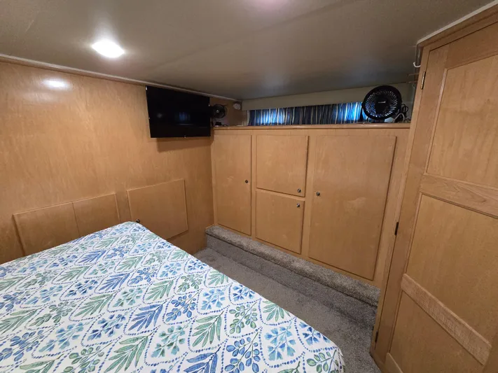  Yacht Photos Pics Bedroom interior of 1997 Navigator 5000 Classic with wood paneling and patterned bedspread.