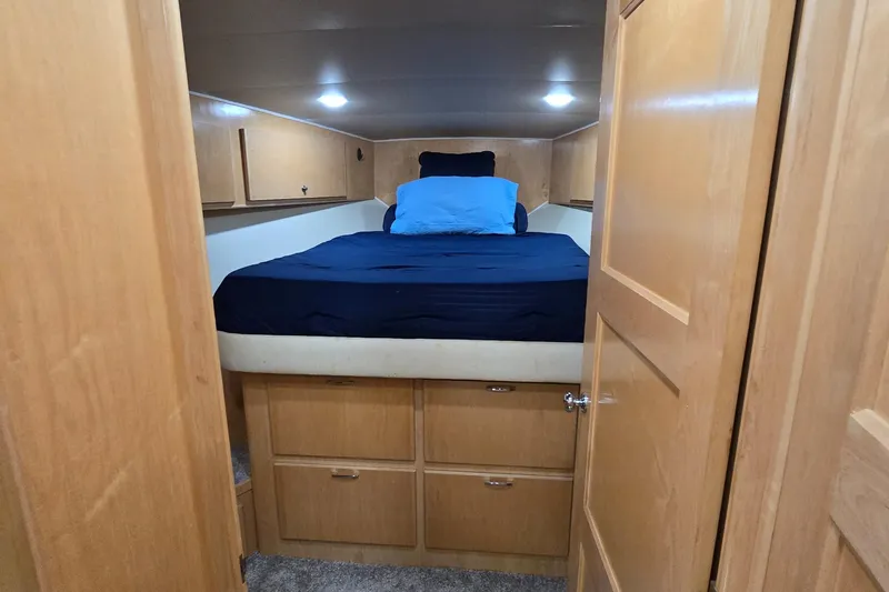  Yacht Photos Pics Cozy bedroom in 1997 Navigator 5000 Classic RV with wooden cabinets and blue bedding.
