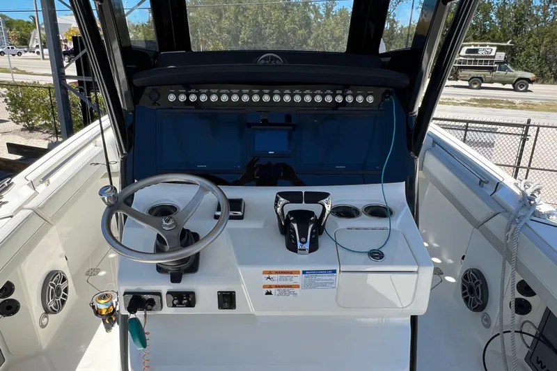  Yacht Photos Pics 2024 World Cat 260 CC-X boat helm with steering wheel and control panel.