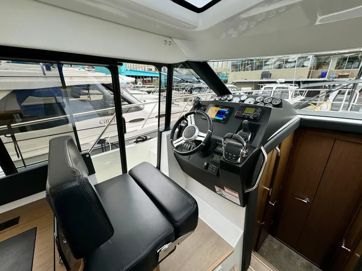 September II Yacht Photos Pics 2018 Jeanneau NC 11 helm station with modern controls and marina view.