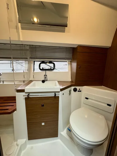 September II Yacht Photos Pics 2018 Jeanneau NC 11 boat bathroom with modern fixtures and wooden cabinetry.