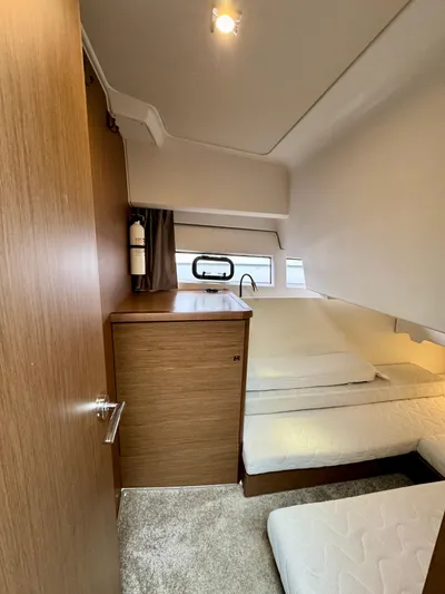 September II Yacht Photos Pics 2018 Jeanneau NC 11 cabin interior with bed and wooden cabinetry.
