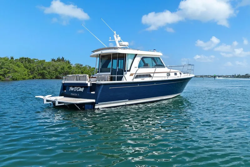 Five O'clock Yacht Photos Pics 2013 Sabre 38 Salon Express yacht on calm water under blue sky.