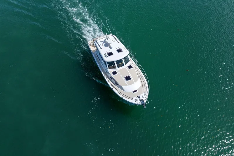 Five O'clock Yacht Photos Pics Aerial view of 2013 Sabre 38 Salon Express cruising on clear water.