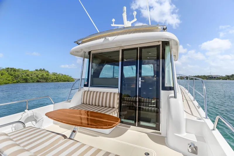 Five O'clock Yacht Photos Pics 2013 Sabre 38 Salon Express yacht with striped seating and wooden table on deck.
