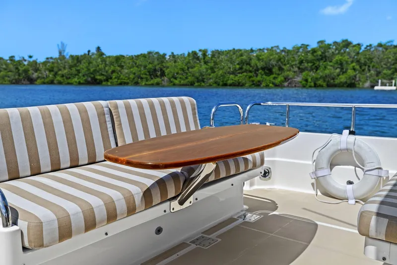 Five O'clock Yacht Photos Pics Outdoor seating on 2013 Sabre 38 Salon Express yacht with striped cushions and wooden table.