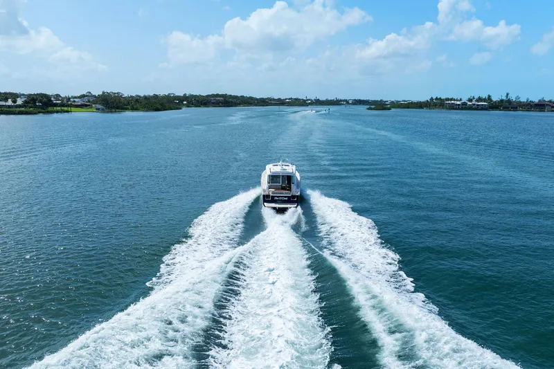 Five O'clock Yacht Photos Pics 2013 Sabre 38 Salon Express cruising on a scenic waterway under a clear blue sky.