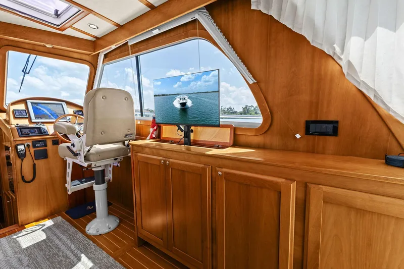 Five O'clock Yacht Photos Pics 2013 Sabre 38 Salon Express interior with helm, navigation screens, and wooden cabinetry.