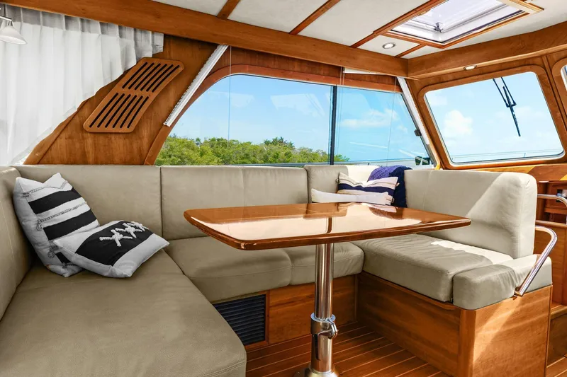 Five O'clock Yacht Photos Pics Interior of 2013 Sabre 38 Salon Express with cozy seating and wooden table.