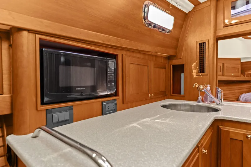 Five O'clock Yacht Photos Pics 2013 Sabre 38 Salon Express galley with microwave, sink, and wooden cabinetry.