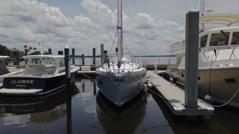 Just A Sign Yacht Photos Pics 2022 Beneteau Oceanis 40.1 sailboat docked between two motorboats.