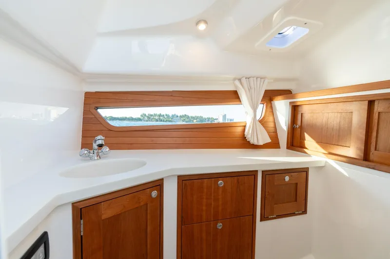 In-stock 2026 Mjm 3-053 Yacht Photos Pics Luxurious interior of 2026 MJM 3 boat with wooden cabinets and scenic window view.
