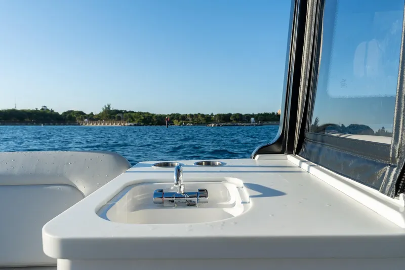 In-stock 2026 Mjm 3-053 Yacht Photos Pics 2026 MJM 3 boat with sink, cruising on a serene lake under clear blue skies.