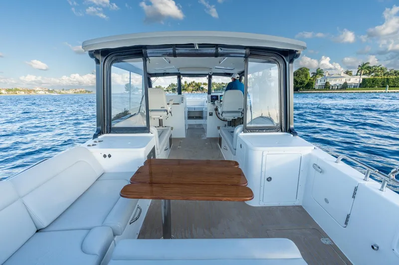 In-stock 2026 Mjm 3-053 Yacht Photos Pics 2026 MJM 3 boat interior with seating and table on a sunny day.