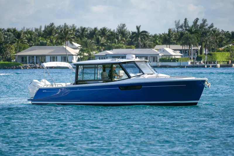 In-stock 2026 Mjm 3-053 Yacht Photos Pics 2026 MJM 3 boat cruising on blue water near coastal homes.