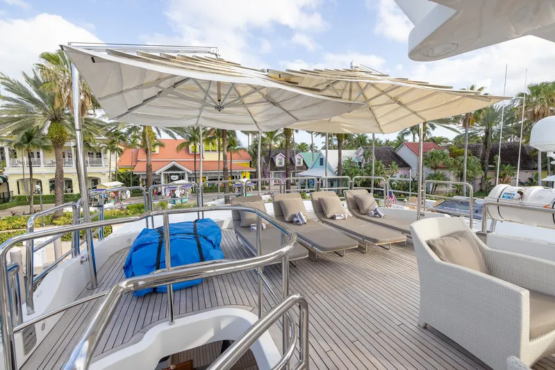 Benetti Classic Yacht Photos Pics Luxurious 2008 Benetti Classic yacht deck with sun loungers and umbrellas, surrounded by tropical scenery.