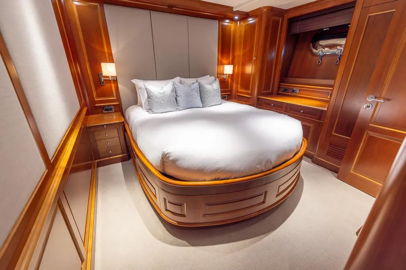 Benetti Classic Yacht Photos Pics Luxurious bedroom on 2008 Benetti Classic yacht with elegant wood paneling and cozy bedding.